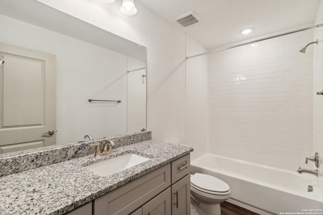 bathroom with toilet, visible vents, shower / washtub combination, wood finished floors, and vanity