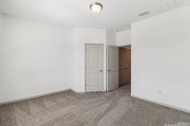 spare room with carpet, visible vents, and baseboards