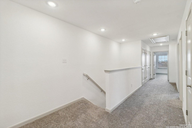 hallway featuring light carpet, baseboards, and recessed lighting