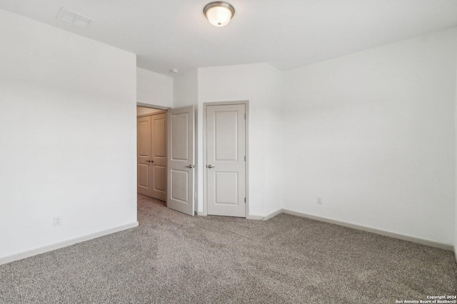 unfurnished bedroom featuring visible vents, carpet flooring, and baseboards