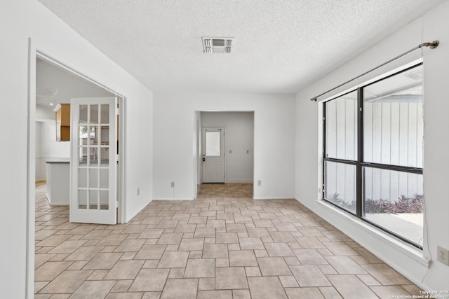 5822 Bennington, San Antonio, TX 78228 - spare room with baseboards, a textured ceiling, and visible vents