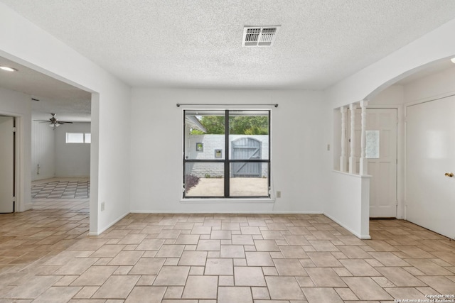 5822 Bennington, San Antonio, TX 78228 - unfurnished room with arched walkways, a ceiling fan, a textured ceiling, and visible vents