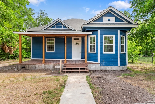 view of front of house with a porch, crawl space, and fence