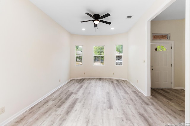 unfurnished room with baseboards, a ceiling fan, visible vents, and light wood-style flooring