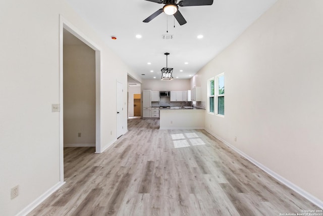 unfurnished living room featuring recessed lighting, light wood finished floors, visible vents, baseboards, and ceiling fan with notable chandelier