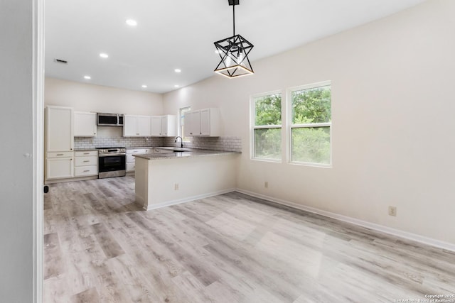 kitchen featuring recessed lighting, white cabinets, light wood-style floors, tasteful backsplash, and appliances with stainless steel finishes