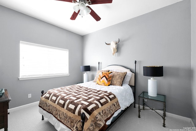 carpeted bedroom with ceiling fan and baseboards