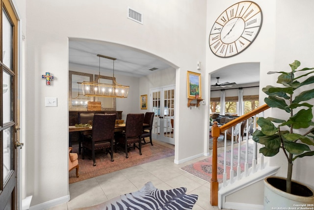 entryway with french doors, arched walkways, visible vents, a ceiling fan, and light tile patterned floors