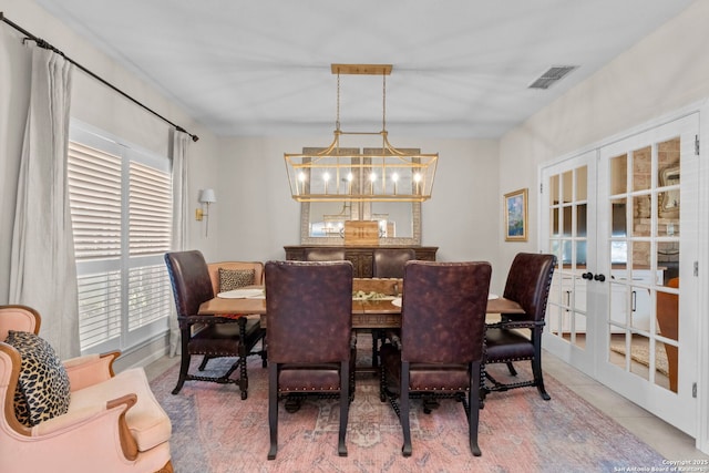 tiled dining room with french doors, visible vents, and a notable chandelier