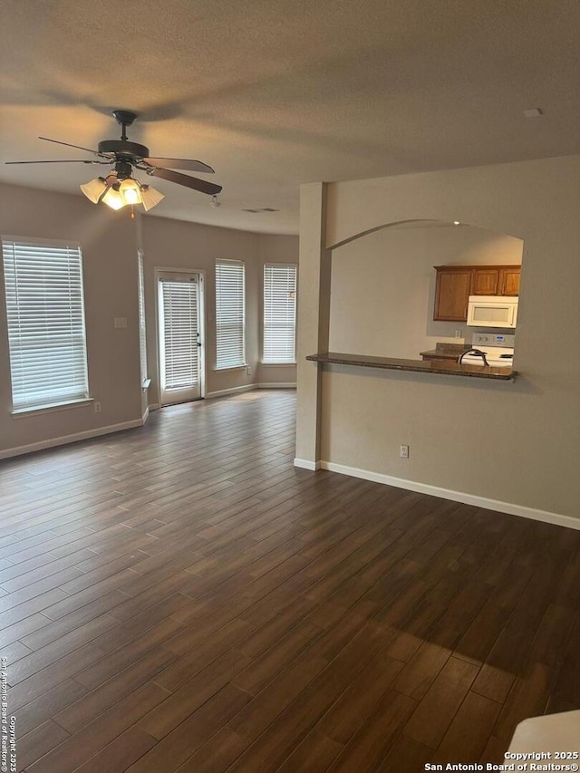791 Sycamore Moon, San Antonio, TX 78216 - unfurnished living room with a ceiling fan, baseboards, and dark wood-style floors