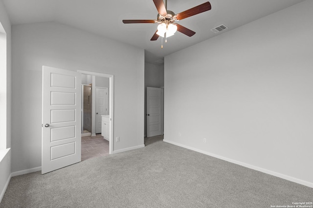 unfurnished bedroom with visible vents, carpet floors, baseboards, connected bathroom, and vaulted ceiling
