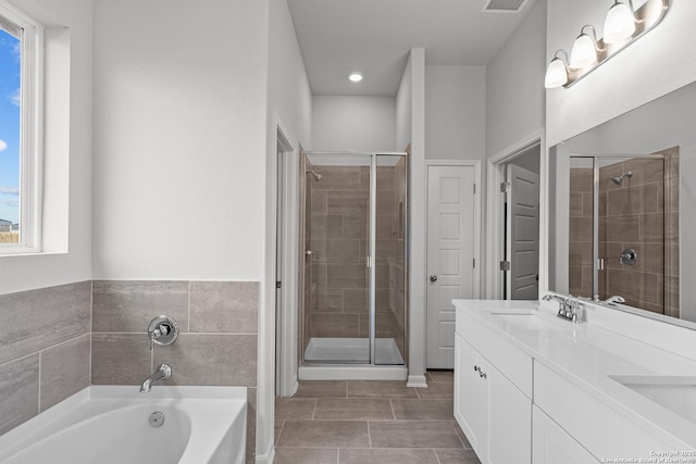 bathroom with double vanity, a sink, a bath, and a shower stall