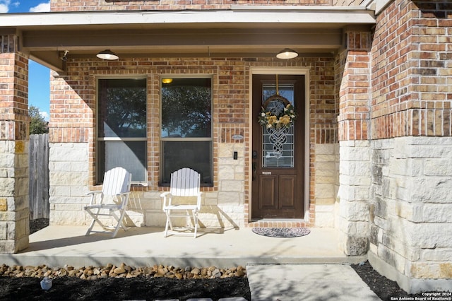 property entrance with brick siding and covered porch