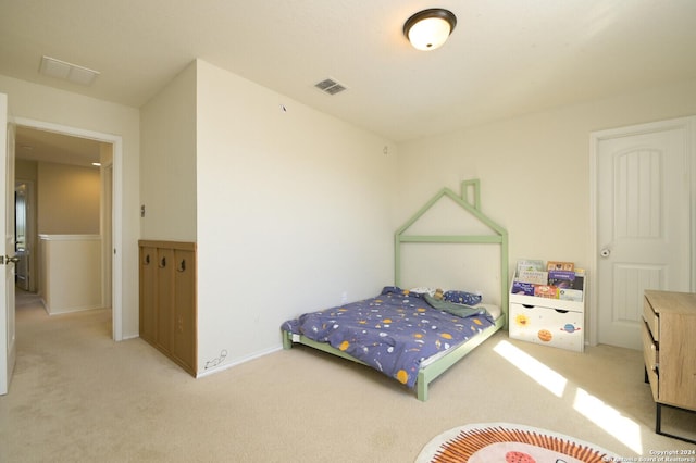 bedroom featuring baseboards, visible vents, and light colored carpet