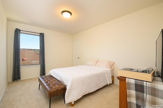 bedroom with light colored carpet and baseboards