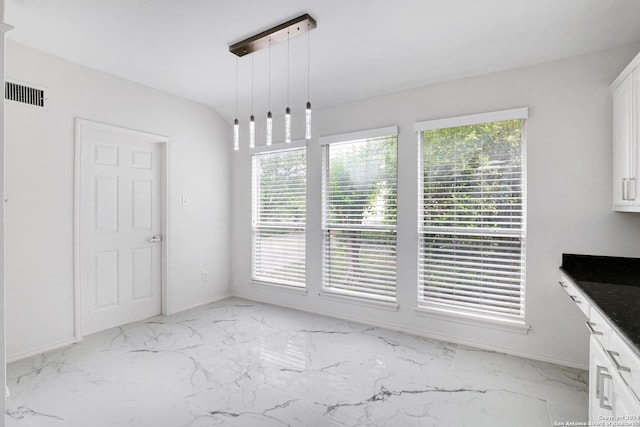 unfurnished dining area with baseboards, visible vents, and marble finish floor