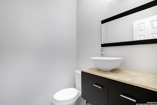 half bathroom featuring toilet and vanity