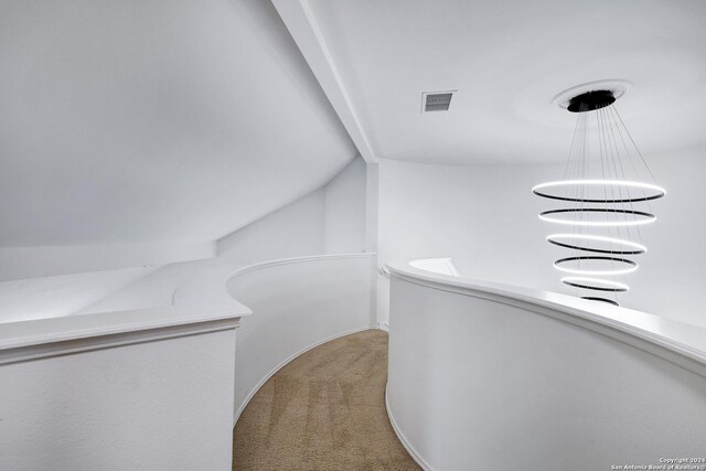 hall featuring a notable chandelier, carpet flooring, an upstairs landing, and visible vents