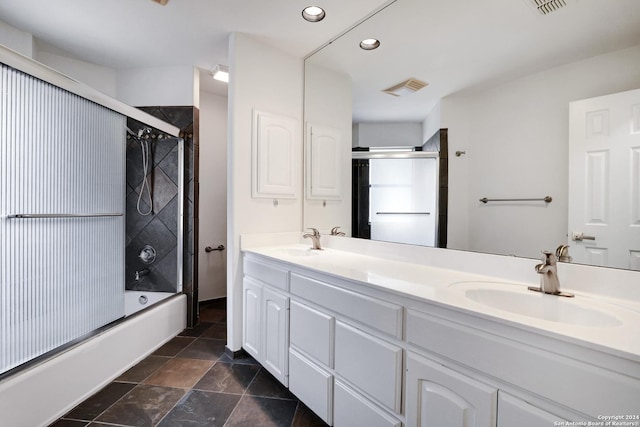 full bath with recessed lighting, double vanity, bath / shower combo with glass door, and a sink