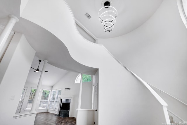 unfurnished living room with dark wood-style floors, a high end fireplace, visible vents, a ceiling fan, and high vaulted ceiling