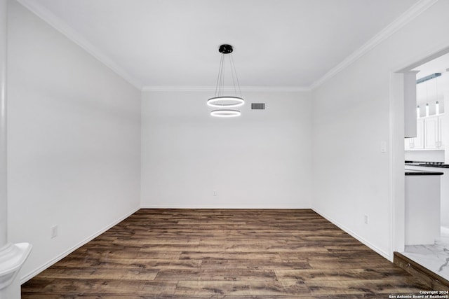 unfurnished dining area featuring baseboards, visible vents, dark wood-style floors, and ornamental molding