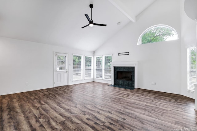 unfurnished living room with wood finished floors, beam ceiling, a ceiling fan, and high vaulted ceiling