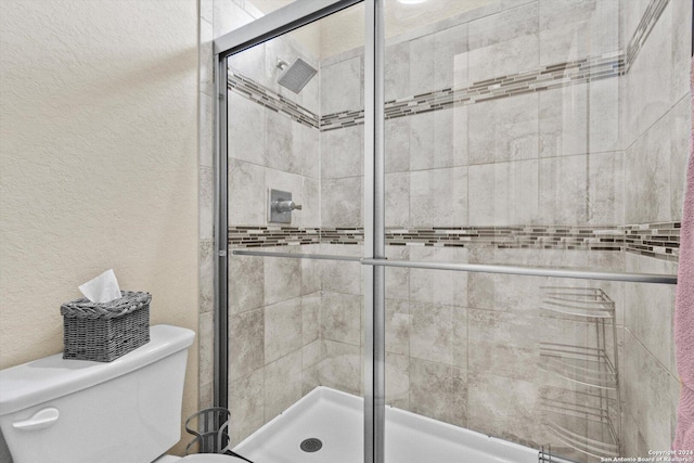 534 Mission Hill Run, New Braunfels, TX 78132 - full bath with a shower stall, a textured wall, and toilet
