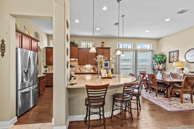 534 Mission Hill Run, New Braunfels, TX 78132 - kitchen with backsplash, visible vents, stainless steel fridge, and dark wood-style floors