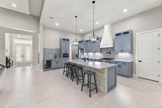 1191 Glenwood, Bulverde, TX 78163 - kitchen with beverage cooler, a chandelier, custom range hood, a kitchen bar, and a sink