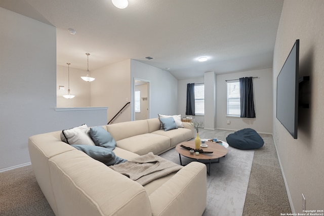 living room featuring baseboards, light colored carpet, and visible vents