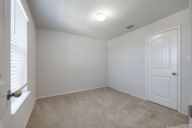 carpeted empty room with baseboards and visible vents