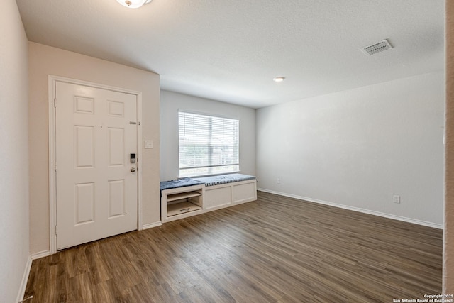 entryway featuring baseboards, visible vents, and wood finished floors