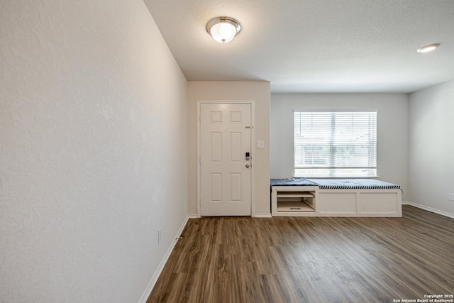 doorway featuring baseboards and wood finished floors