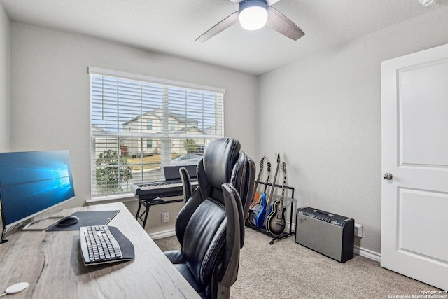 home office with plenty of natural light, a ceiling fan, baseboards, and carpet