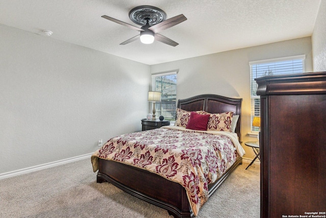 carpeted bedroom with a ceiling fan and baseboards