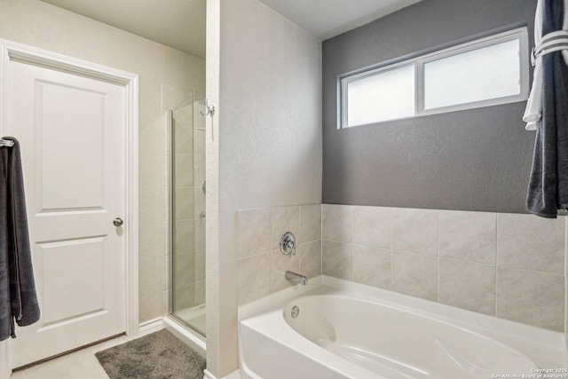 full bath with a shower stall, a garden tub, a textured wall, and tile patterned floors