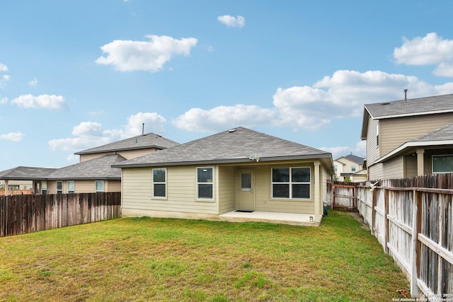 back of house with a patio area, a lawn, and a fenced backyard