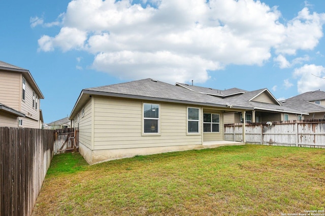 rear view of property featuring a fenced backyard, a patio area, and a lawn