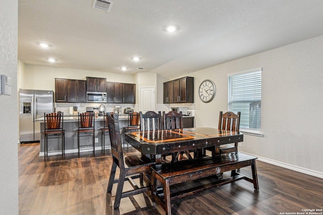 dining space with dark wood finished floors, baseboards, visible vents, and recessed lighting