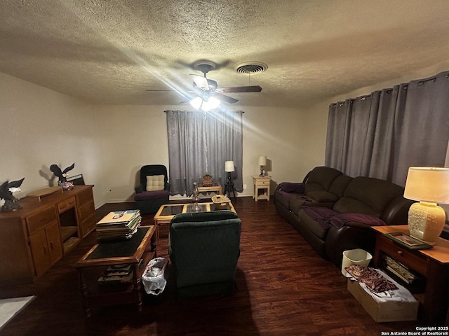living area featuring a textured ceiling, baseboards, visible vents, a ceiling fan, and wood finished floors