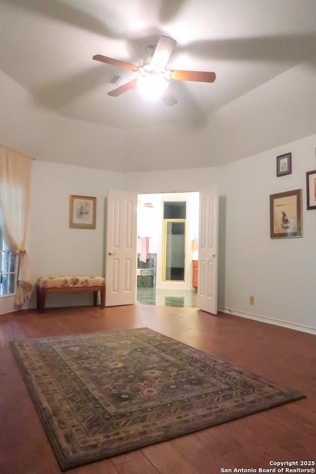 interior space featuring wood finished floors, a ceiling fan, and baseboards