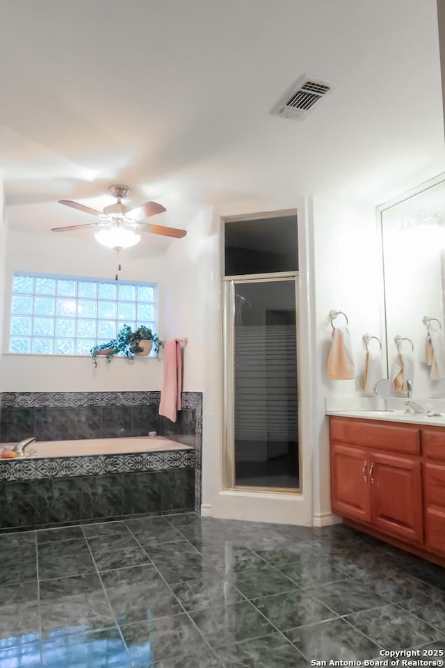bathroom featuring a shower stall, a garden tub, vanity, ceiling fan, and visible vents
