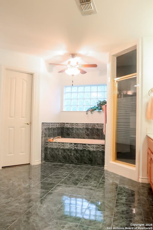 full bath with a shower stall, a garden tub, vanity, ceiling fan, and visible vents