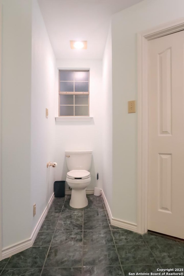 bathroom with baseboards and toilet