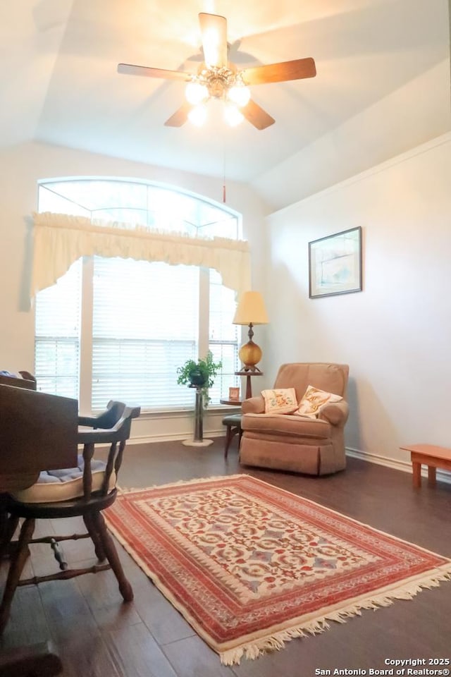 living area with vaulted ceiling, baseboards, a ceiling fan, and a healthy amount of sunlight