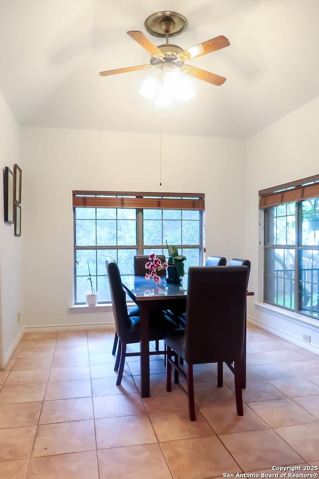 dining room featuring a ceiling fan, baseboards, and light tile patterned floors