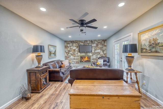 living area featuring light wood finished floors, baseboards, recessed lighting, a ceiling fan, and a fireplace