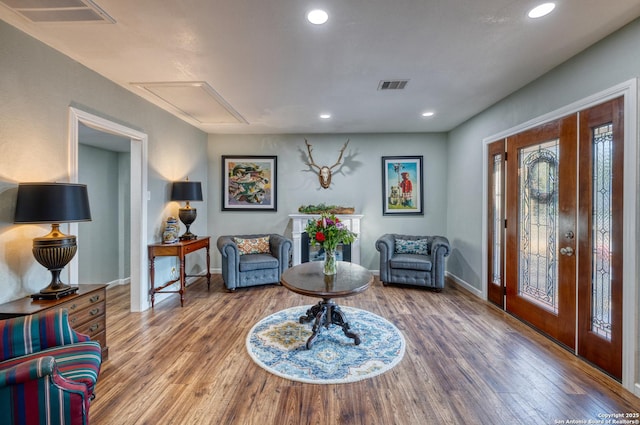 foyer with baseboards, wood finished floors, and visible vents