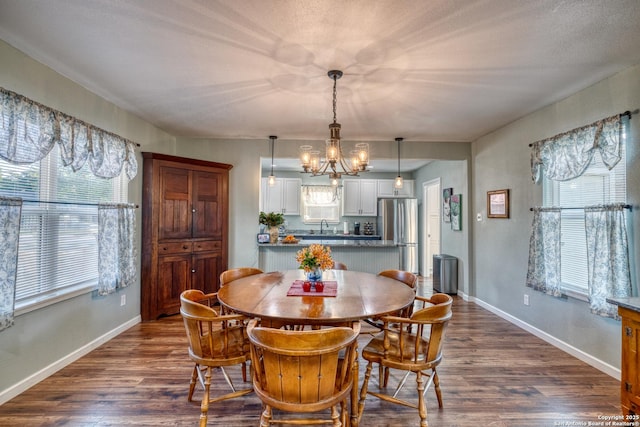 dining area with dark wood-type flooring, baseboards, and a notable chandelier
