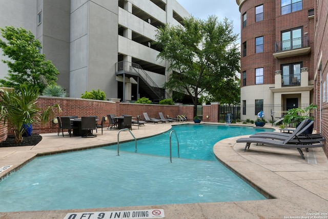 pool featuring fence and a patio
